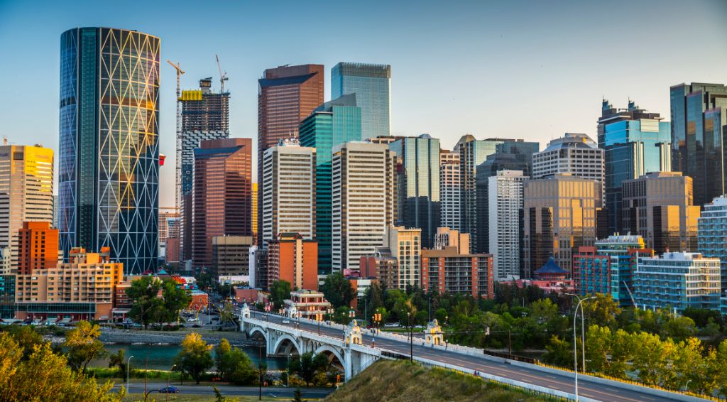 Calgarys skyline with its skyscrapers and office buildings. Bow river and centre Street Bridge in the foreground. Alberta - Canada