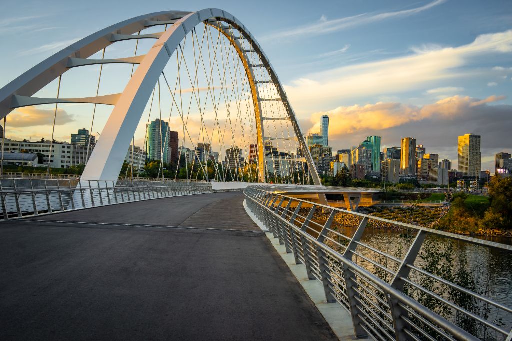 Edmonton, Alberta, Canada skyline at dusk with suspension bridge in foreground and clouds