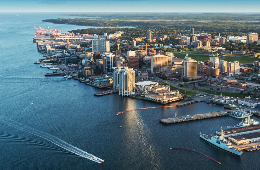 A low altitude aerial view of the Halifax skyline and waterfront in late evening.