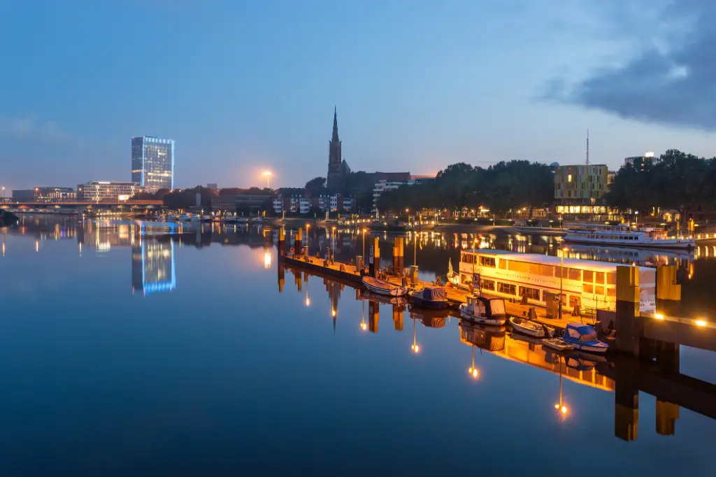 Reflection of Bremen skyline in the calm waters of river Weser, in Bremen Germany.