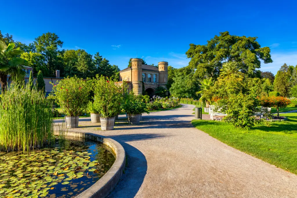 Karlsruhe, Deutschland. Blick auf den Botanischen Garten in Karlsruhe bei blauem Himmel mit Schloss im Hintergrund