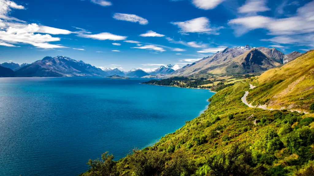 Summer view of Lake Wakatipu and the road from Queenstown to Glenorchy.  Southern Alps mountains in the distance.