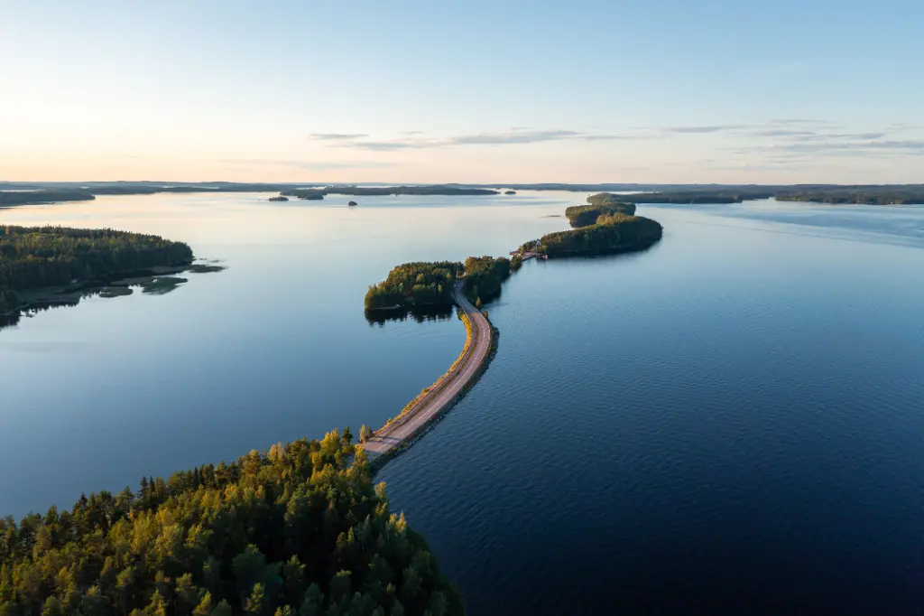 Pulkkilanharju ridge road and calm Päijänne lake in summer in Finland.